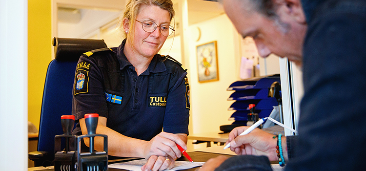 Customs officer and customer fill in paperwork when clearing customs.