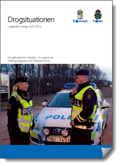 En tulltjänsteman och en polis står framför en tjänstebil.