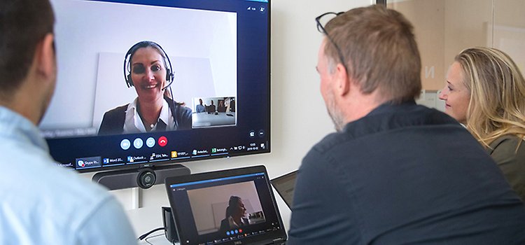 Tre personer har ett digitalt möte, sitter framför en skärm.